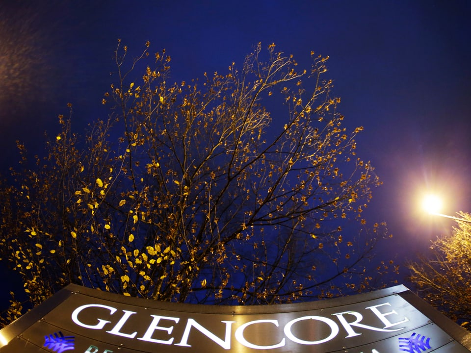 Das Firmenlogo Glencore in mitten von Bäumen.