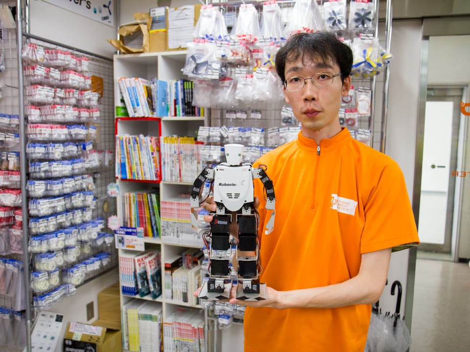 Japaner mit Roboter in der Hand.