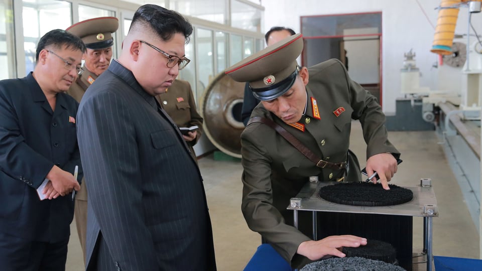 Kim lässt sich von einem uniformierten Militär etwas vorführen.