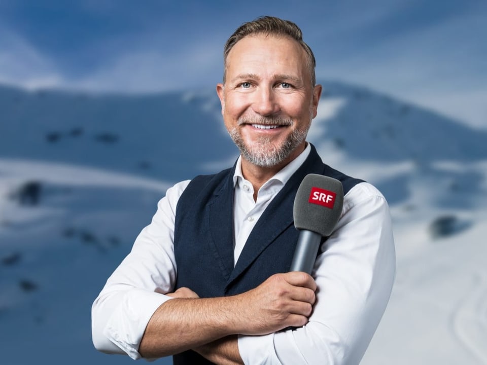Stösst zum Schweizer Radio und Fernsehen Abplanalp mit Mikrofon vor Bergkulisse