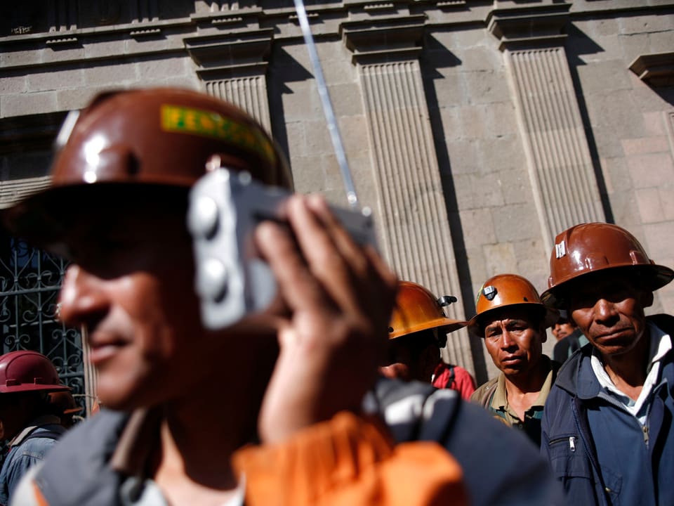 Bolivianischer Arbeiter hält sich ein Radio ans Ohr.