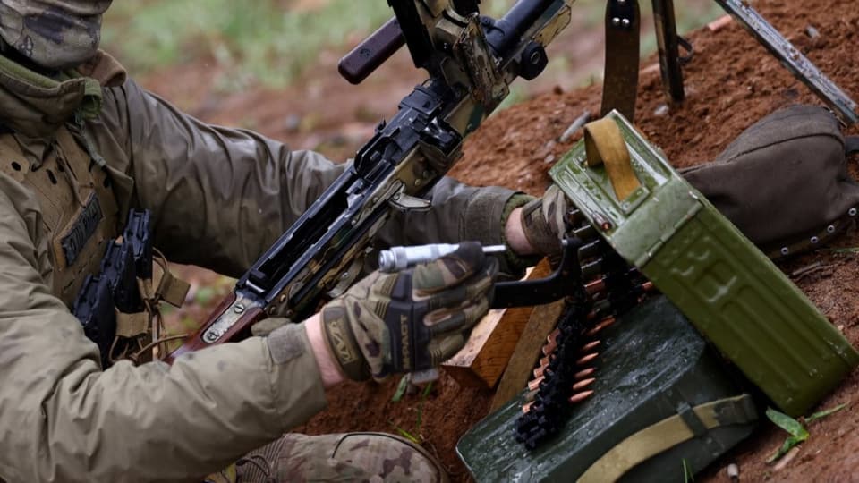 Ein ukrainischer Soldat manipuliert an seiner Waffe, um sie zu testen.