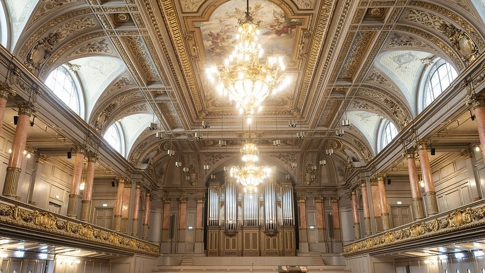 Üppig dekorierter Saal mit goldenem Dekor und hell strahlendem kronleuchter