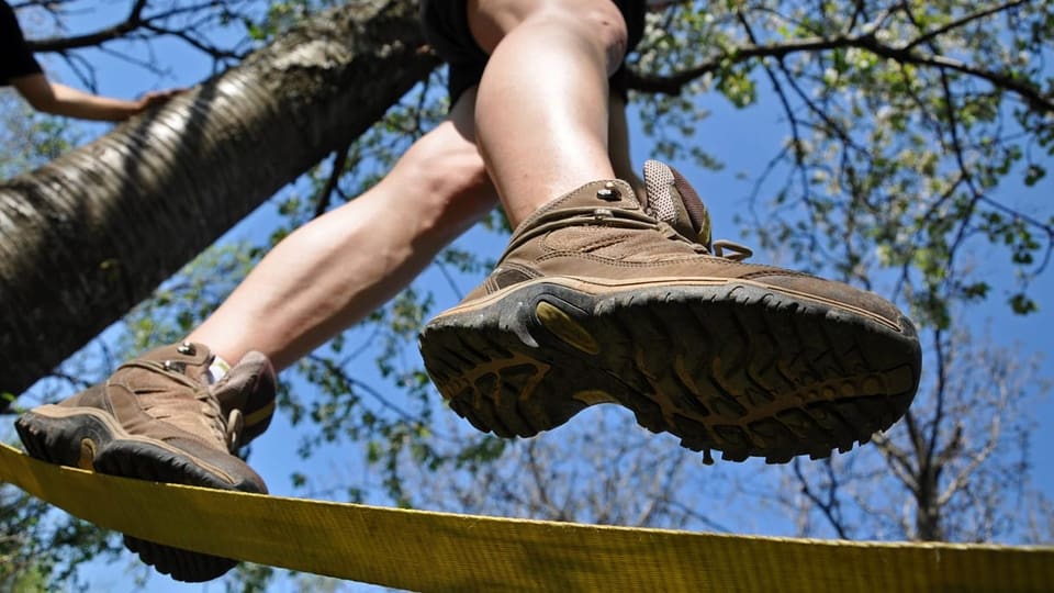 ein Wanderer läuft auf einer Slackline