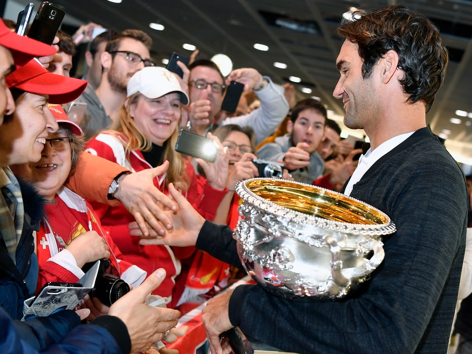 Federer mit Pokal und Fans.