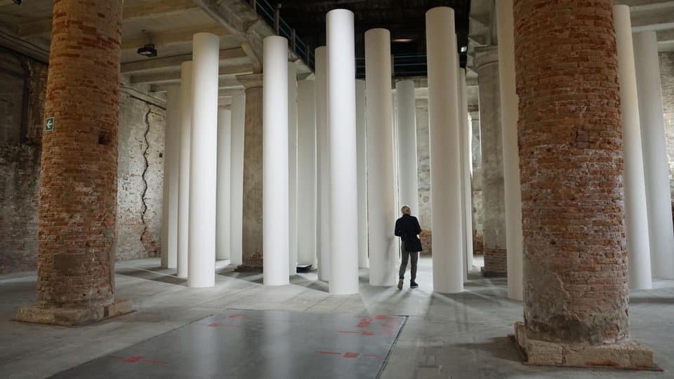 Ein grosser Raum mit zwei grossen gemauerten Säulen, dahinter viele weisse kleinere Säulen.