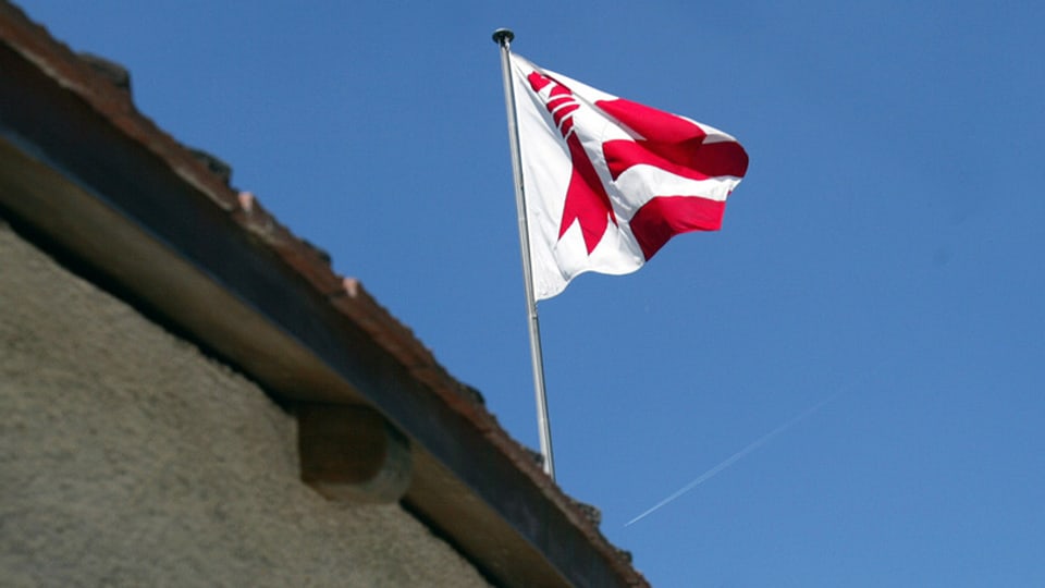 Die Fahne des Kantons Jura vor blauem Himmel