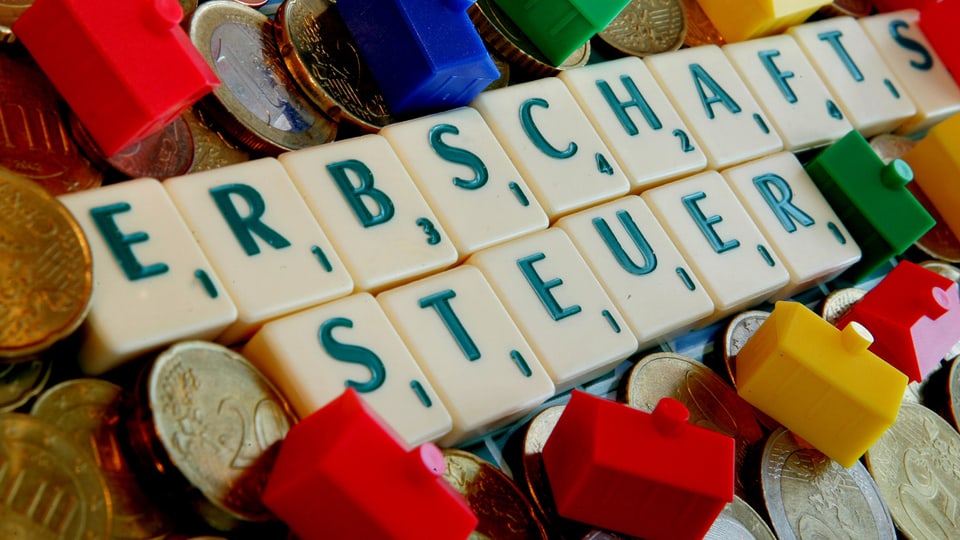 Scrabble-Steine mit Münzen und Monopoly-Häusern
