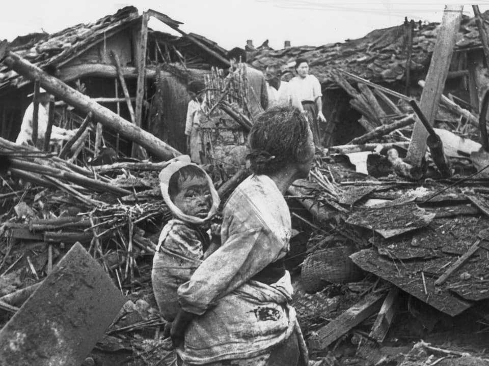 Eine Grossmutter mit ihrem Kind in einem zerstörten Teil von Pjöngjang.