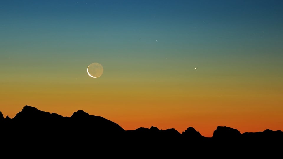Mond nach Sonnenuntergang über Bergketten