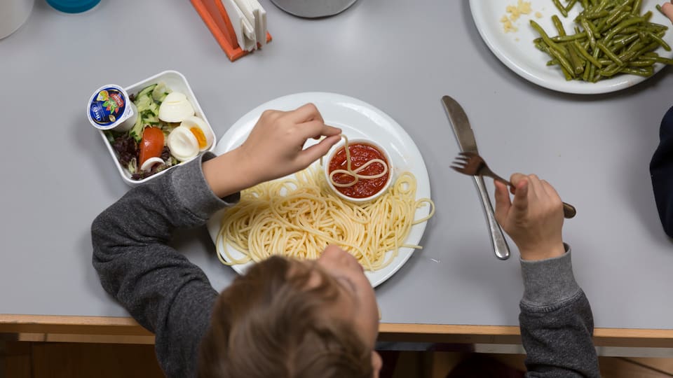 Ein Kind isst Spaghetti