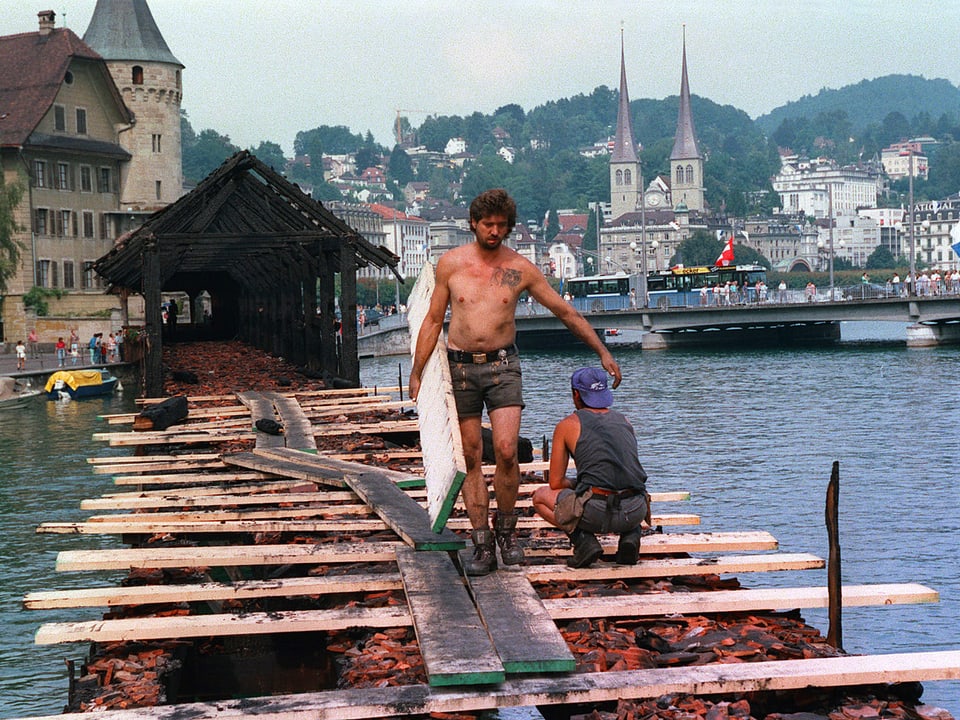 Arbeiter auf zerstörter Brücke.