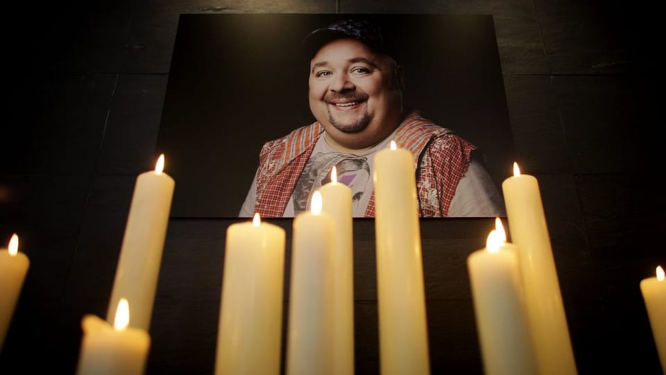 Ein Foto von Bach hängt über brennenden Kerzen.