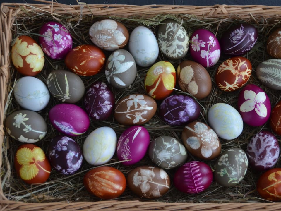 Ein Korb voller farbiger Eier.