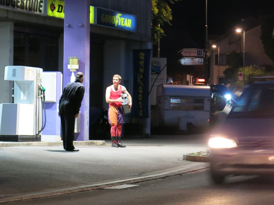 Zwei Männer streiten an einer Tankstelle.