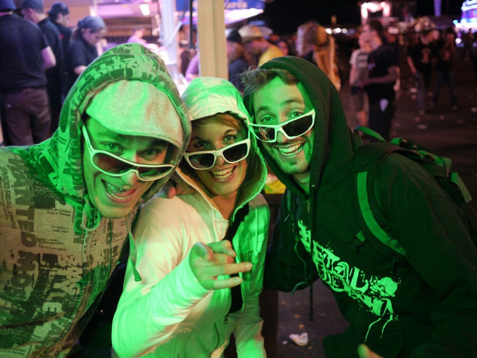 Drei Festivalbesucher mit weissen Sonnenbrillen.