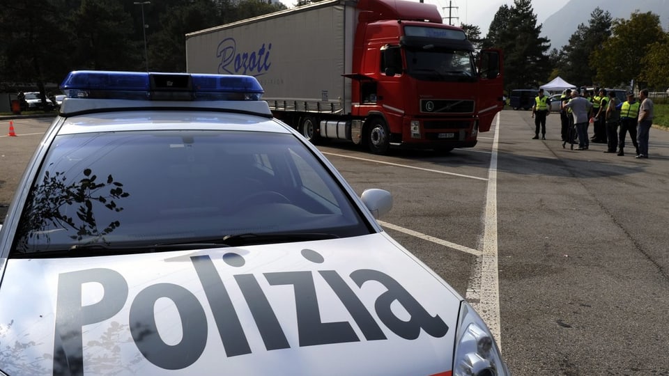 Auto der Tessiner Kantonspolizei vor einen Lastwagen. Dahinter einige Polizeiautos.