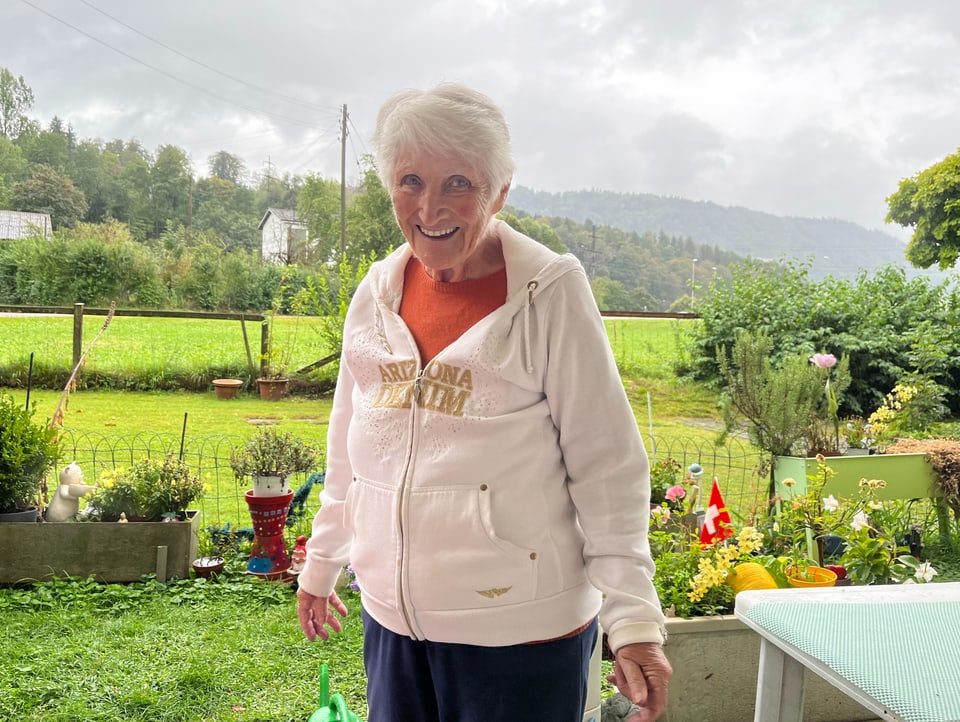 Hedy Zinke eine ältere Frau steht in ihrem grünen Garten.