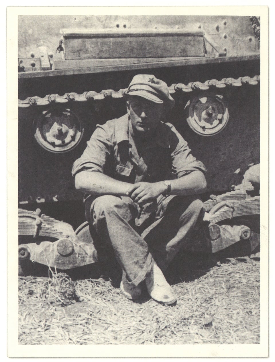 Alte Fotografie von einem Mann, der vor einem Panzer sitzt.
