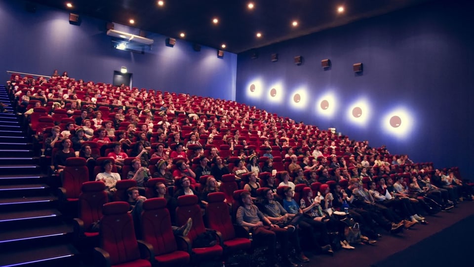 Menschen in einem Kinosaal, die das Final der League of Legends schauen als Public Viewing.