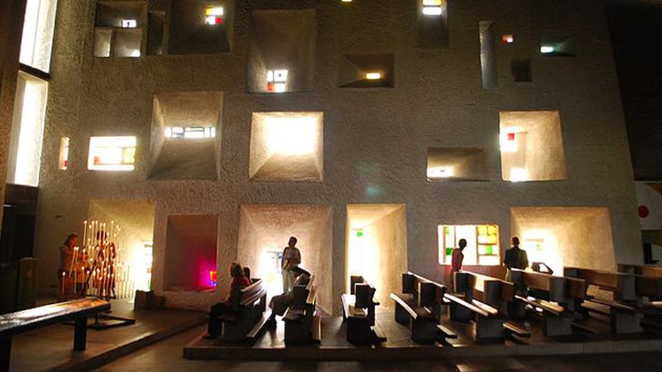 Der Innenraum der Corbusier-Kapelle in Ronchamp ist hell erleuchtet.