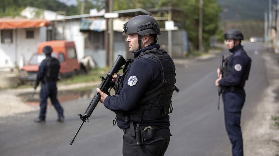 Kosovarische Polizisten sichern die Strasse während eines laufenden Polizeieinsatzes in der Stadt Zvecan