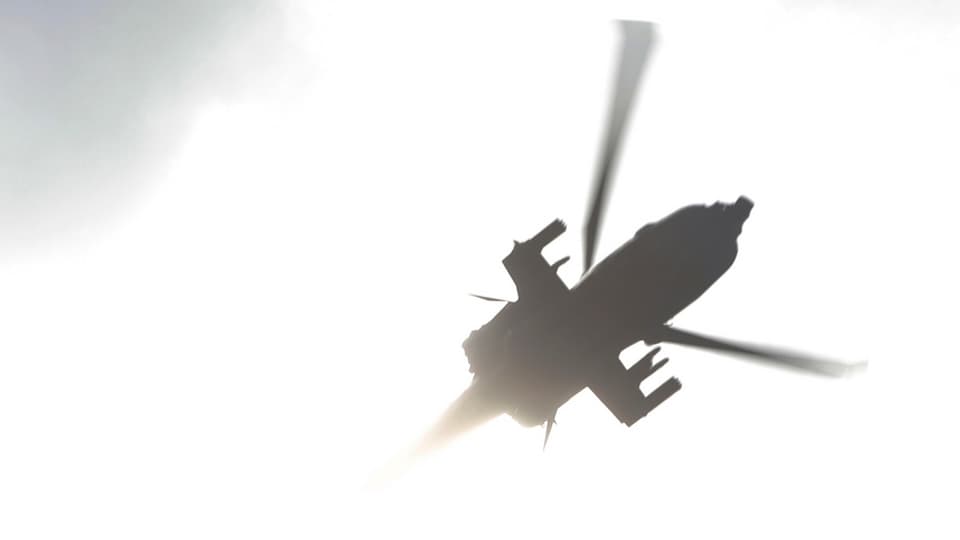 Silhouette eines Helikopters, von unten aufgenommen.