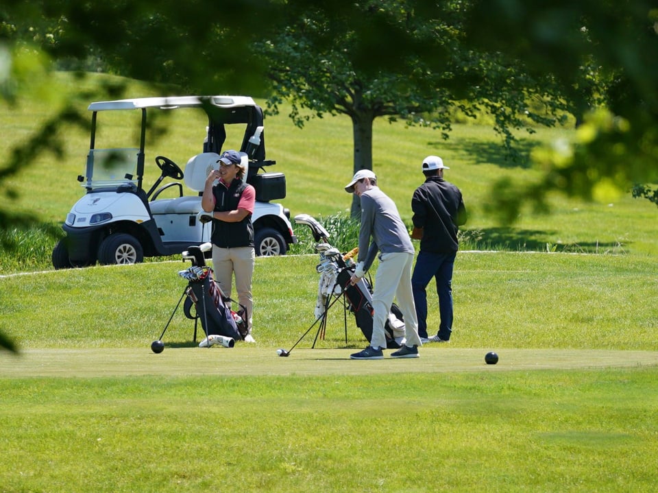 Verschiedene Personen spielen Golf im 