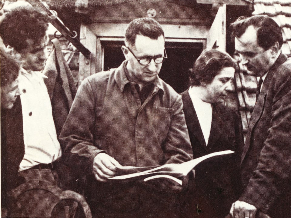 Brecht hält ein Manuskript in den Händen. Um ihn stehen vier Freunde. 