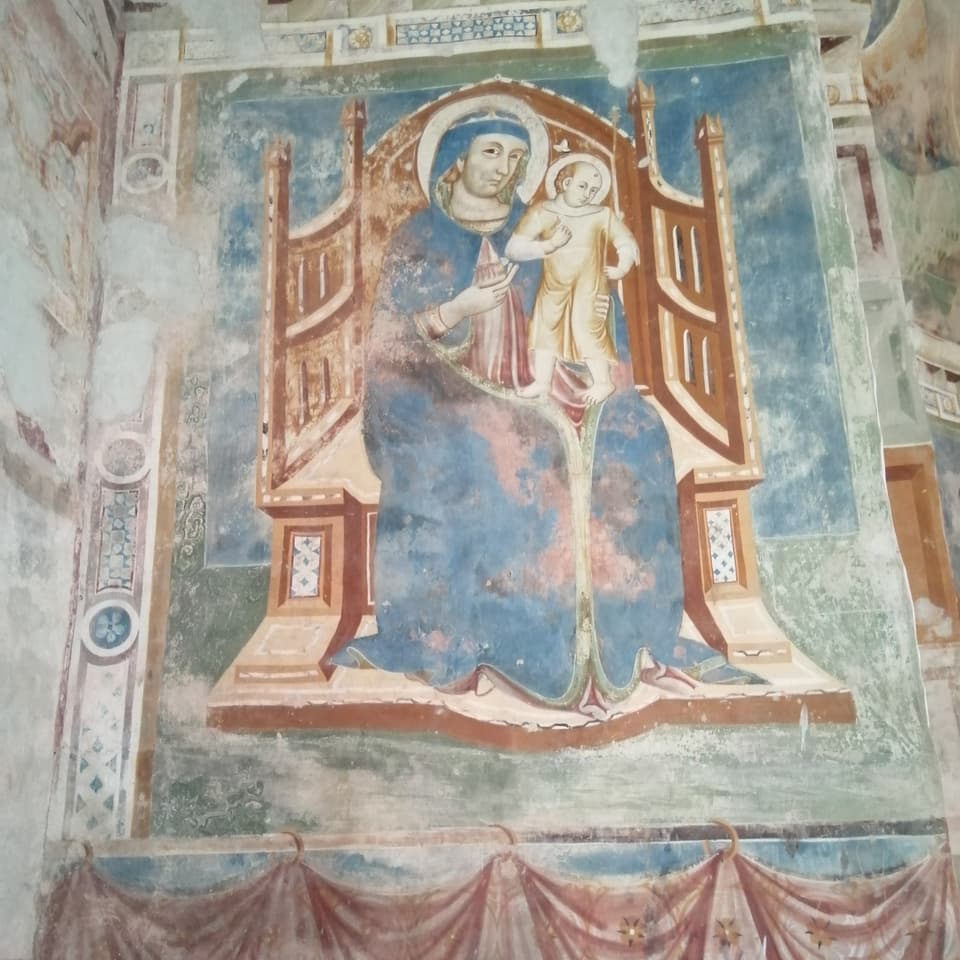 Malerei einer Heiligen und einem Engel an einer Kirchenwand.