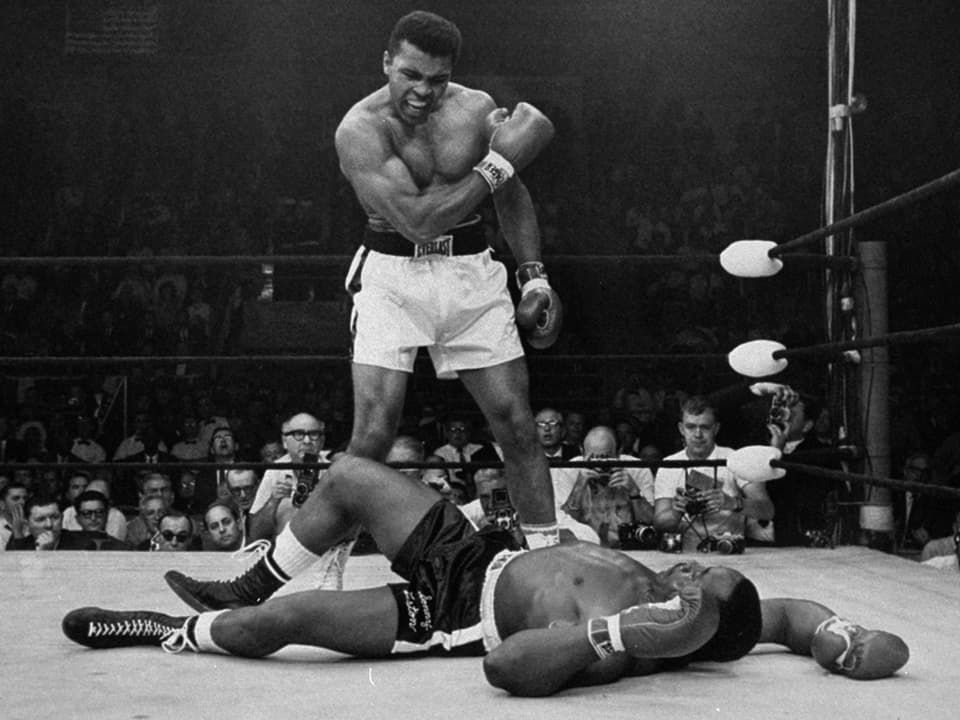 Muhammad Ali steht über dem am Boden liegenden Herausforderer Sonny Liston im Kampf vom Mai 1965