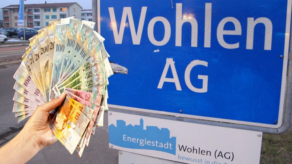 Eine Hand hält ein Bündel Banknoten, im Hintergrund Ortsschild von Wohlen. 