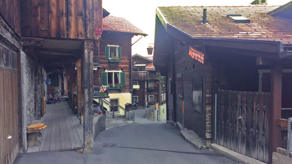Enge Strasse durch alte Bündner Holzhäuser.