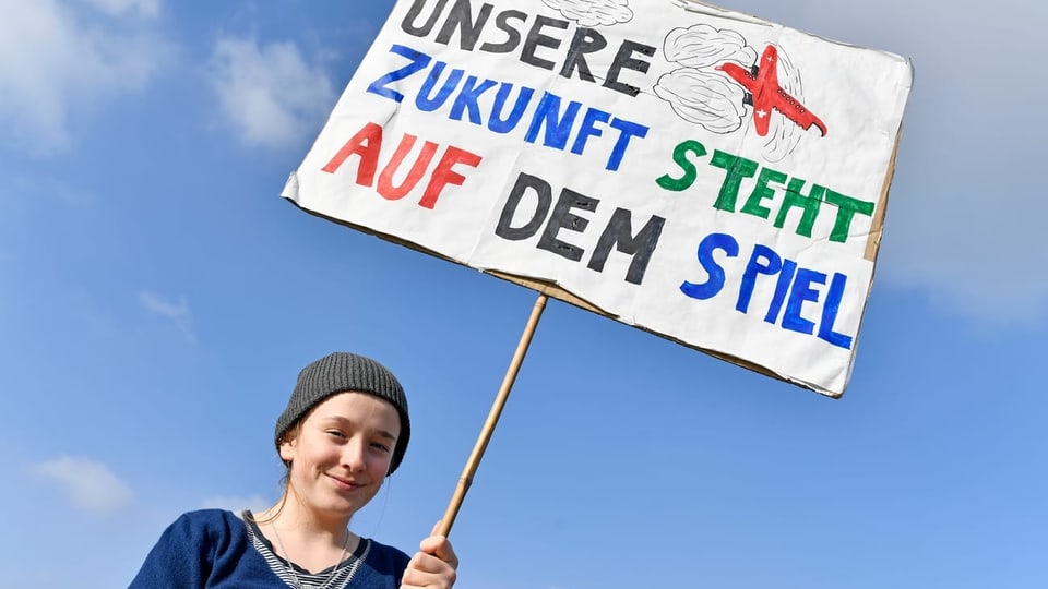 Klimastreik: EIne junge Frau mit einem Plakat, auf dem steht: «Unsere Zukunft steht auf dem Spiel.»