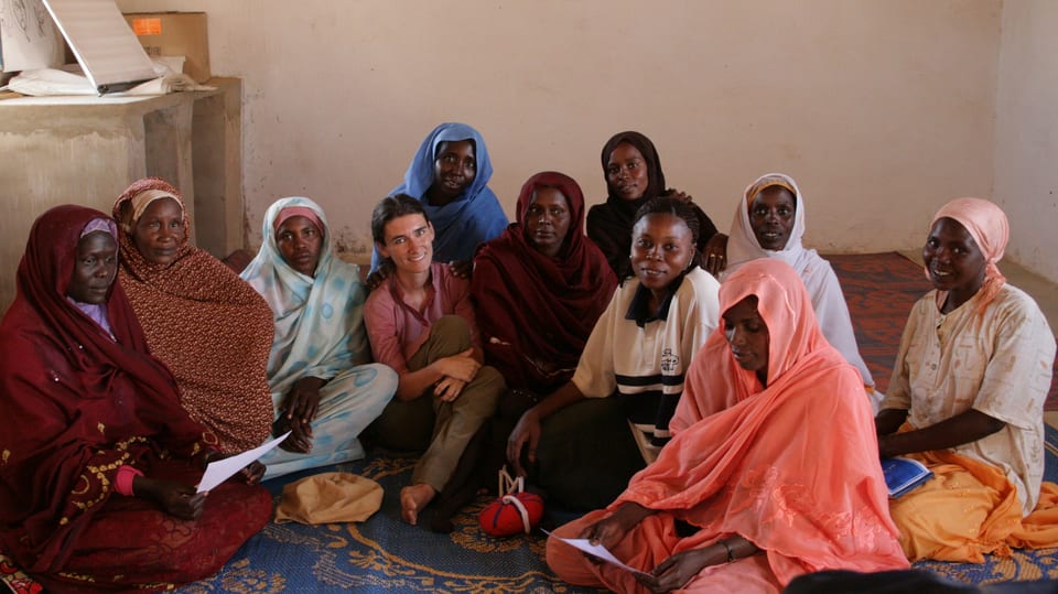 Nelly Staderini inmitten einer Gruppe afrikanischer Frauen sitzend