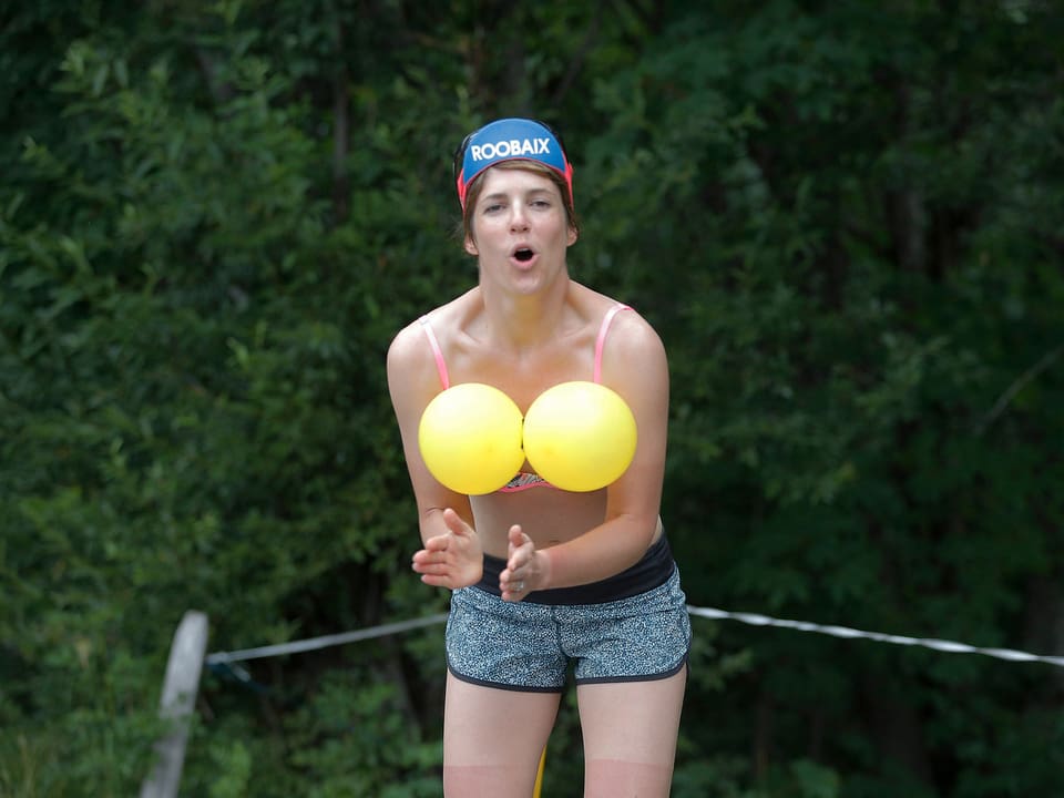 Zuschauerin mit gelben Ballonen vor den Brüsten