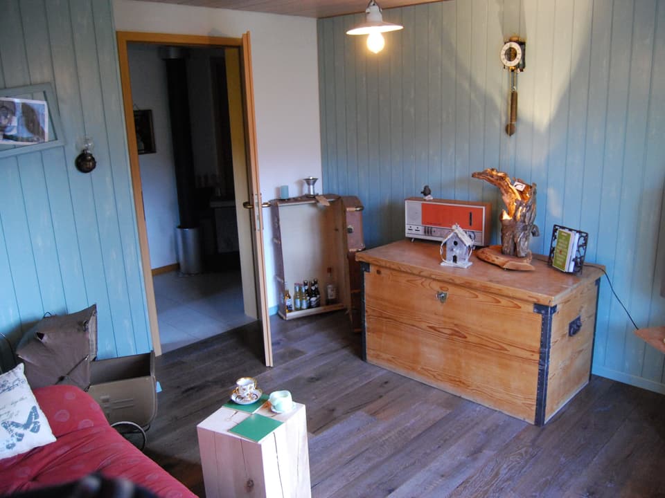 Zimmer mit Kisten, Bett und Holz, welches als Tisch dient