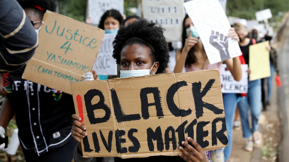 Eine Dmo mit jungen Schwarzen und Black-Lives-Mätter-Parolen auf Kartons.