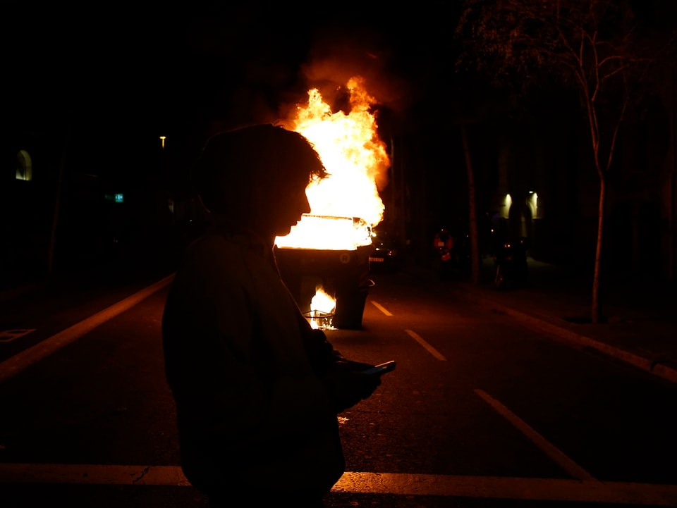 Mann vor brennendem Auto.