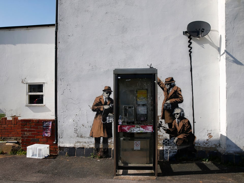 Graffiti von Spionen welche eine Telefonzell belauschen.