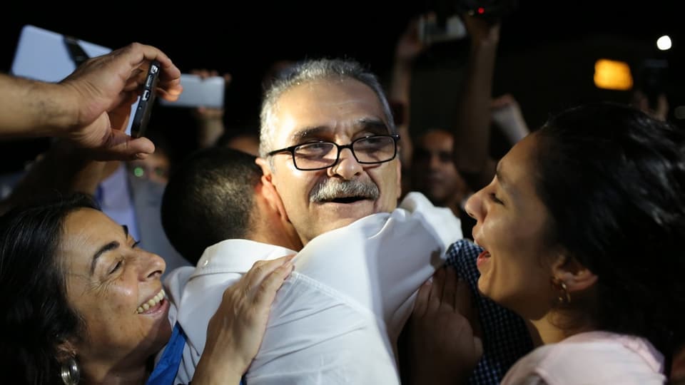 Angehörige umarmen den lachenden Journalisten Onder Celik, nachdem er freigelassen wurde.