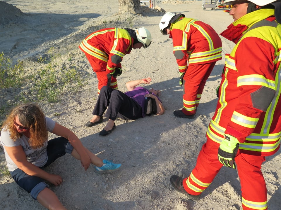 Zwei Frauen liegen am Boden. Feuerwehrleute kümmern sich um sie