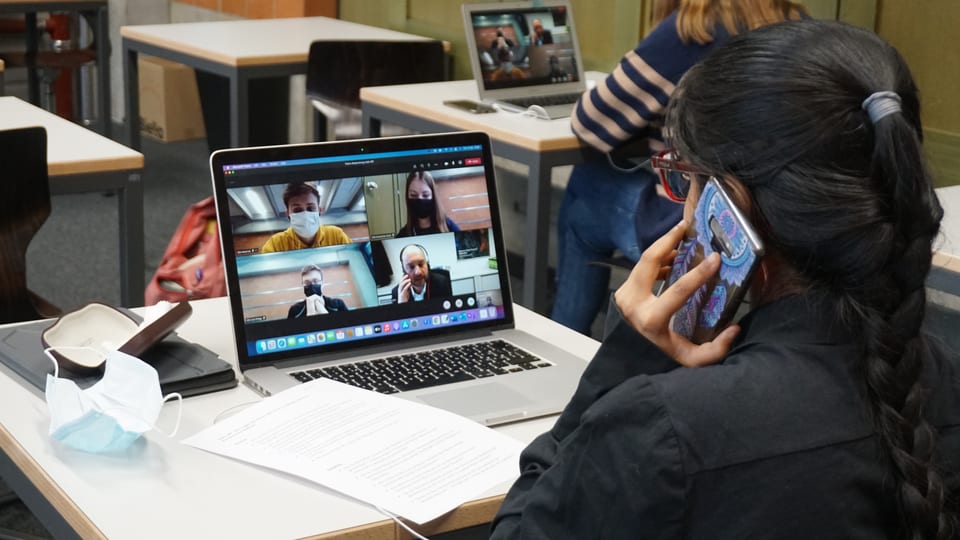 Via Handy und Laptop verfolgen die Schülerinnen und Schüler den Videoaustausch.