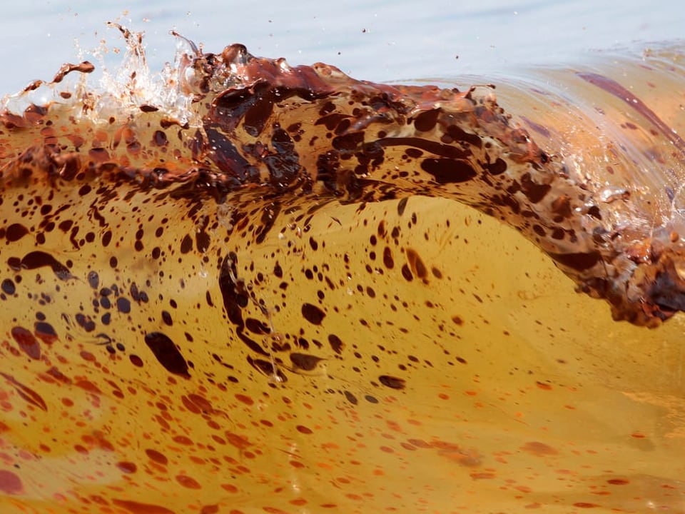 Ölflocken in einer braunen Meereswelle
