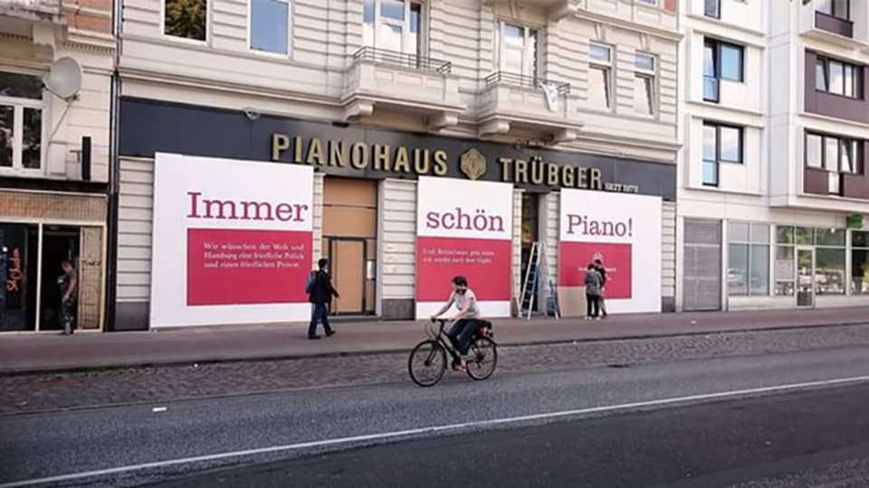 In drei Schaufenstern stehen die Wort: Immer schön Piano!