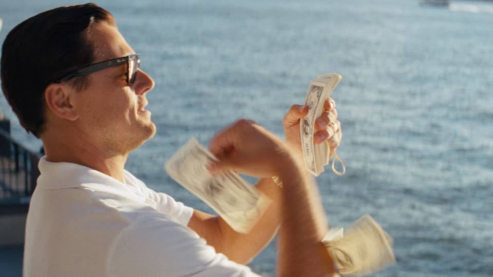 Leonardi DiCaprio wirft Geldscheine ins Meer.