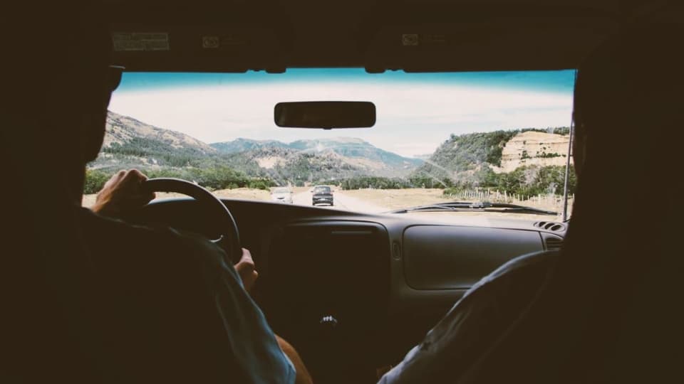Ausblick aus einem fahrenden Auto auf eine Strasse.