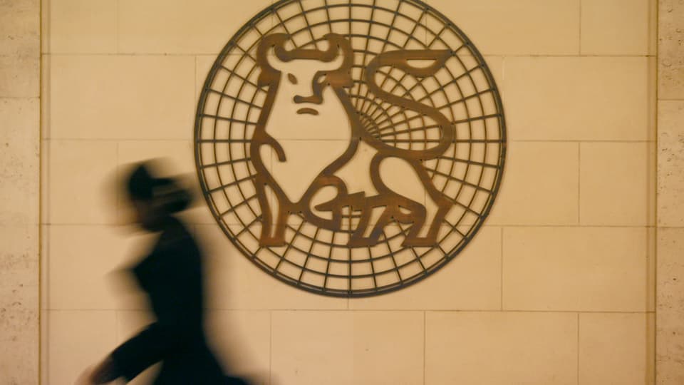 Eine Frau eilt am Logo der Bank Merrill Lynch London vorbei.