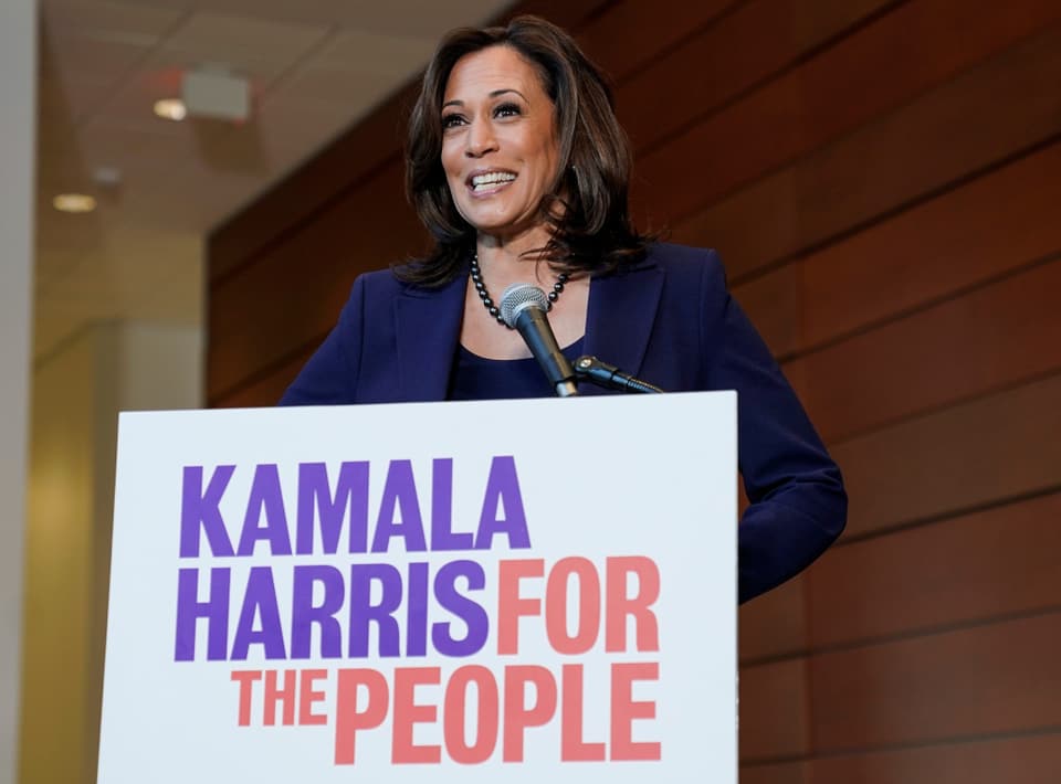 Kamala Harris mit einem Wahlkampf-Plakat.