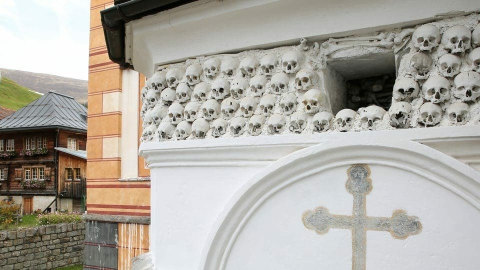 An der Wand eines kirchengebäudes sind Totenschädel eingemauert